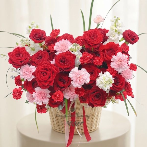 Giỏ hoa tặng sinh nhật người yêu với hoa hồng đỏ, cẩm chướng hồng và trắng, thiết kế lãng mạn và nổi bật.