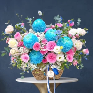 Giỏ hoa sinh nhật phong cách tinh tế với tone xanh dương – hồng pastel, nổi bật với hoa mẫu đơn xanh, hồng phấn và cẩm chướng trắng.