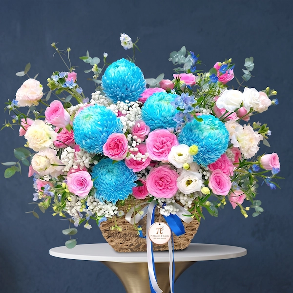 Giỏ hoa sinh nhật phong cách tinh tế với tone xanh dương – hồng pastel, nổi bật với hoa mẫu đơn xanh, hồng phấn và cẩm chướng trắng.