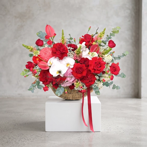 Giỏ hoa tặng sếp nữ sang trọng với hoa hồng đỏ, lan hồ điệp trắng, baby trắng, mẫu đơn và lá bạc.