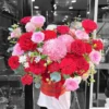 Nhân viên cắm hoa đang chuẩn bị giỏ hoa tươi rực rỡ tại shop hoa gần bệnh viện.