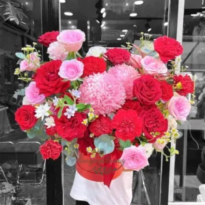 Nhân viên cắm hoa đang chuẩn bị giỏ hoa tươi rực rỡ tại shop hoa gần bệnh viện.