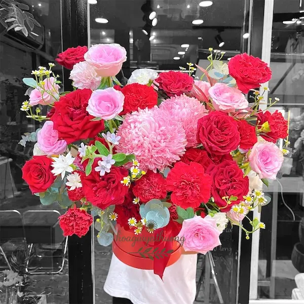 Giỏ hoa rực rỡ từ tiệm hoa tươi giao liền với sắc đỏ, hồng, tím, cắm tay đang được giao hàng.