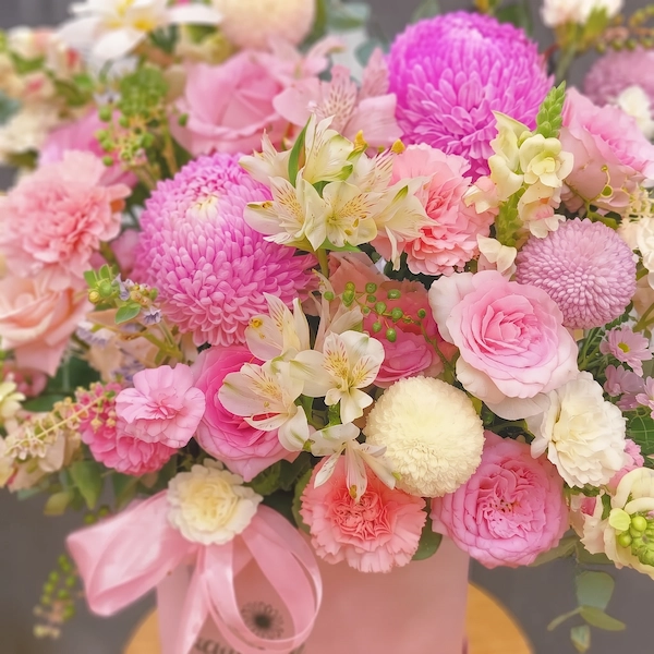 Giỏ hoa sinh nhật ngọt ngào với tông màu hồng pastel dịu dàng, gồm hoa hồng, hoa cúc và hoa lá trang trí, phù hợp làm quà tặng.