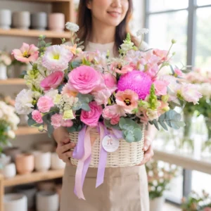 Khách hàng đang ôm giỏ hoa tươi hồng pastel sang trọng từ shop hoa tươi gần đây có giao hàng nhanh chóng tận nơi.