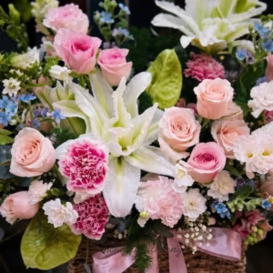 Người phụ nữ hạnh phúc ôm giỏ hoa tươi, shop hoa tươi giao trong 2h nhanh chóng.