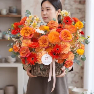 Mẫu giỏ hoa tươi tông màu cam ấm áp và rực rỡ từ tiệm bán hoa gần đây, thiết kế sang trọng phù hợp làm quà tặng.