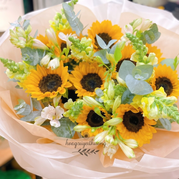 Cô gái cầm bó hoa hướng dương tươi thắm tại tiệm hoa gần đây mở cửa 24/7 phục vụ khách hàng.