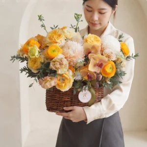 Khách hàng nâng niu mẫu giỏ hoa sinh nhật hiện đại “Nắng Mai Rực Rỡ” tông vàng cam.