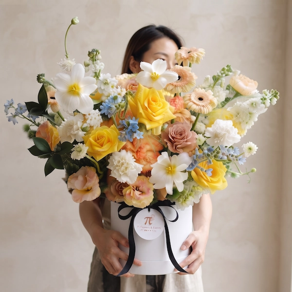 Khách hàng rạng rỡ ôm giỏ hoa sinh nhật tươi dáng cao tone màu vàng kem hiện đại.